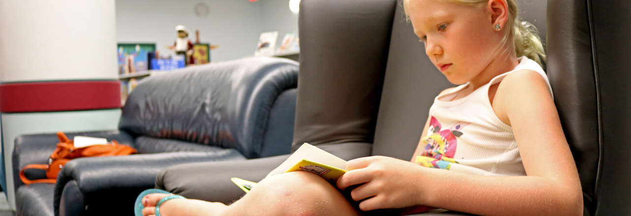 child reading book in chair