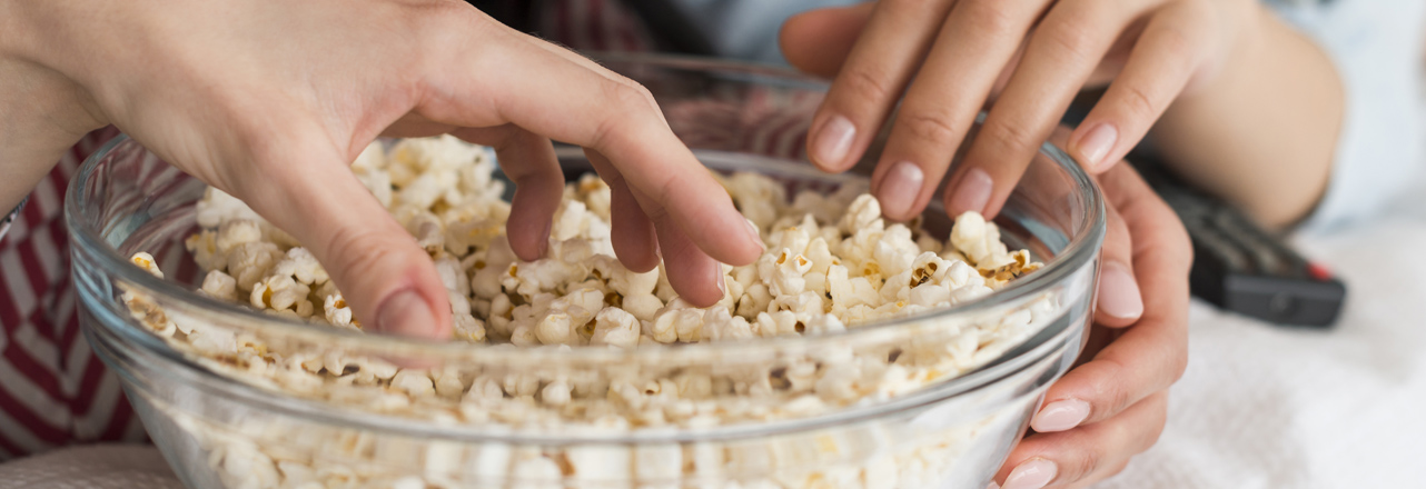 hands in popcorn bowl