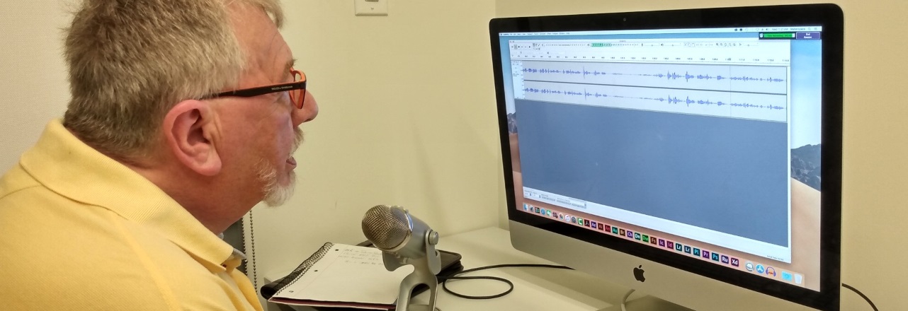 Man recording his voice on to a computer with a microphone
